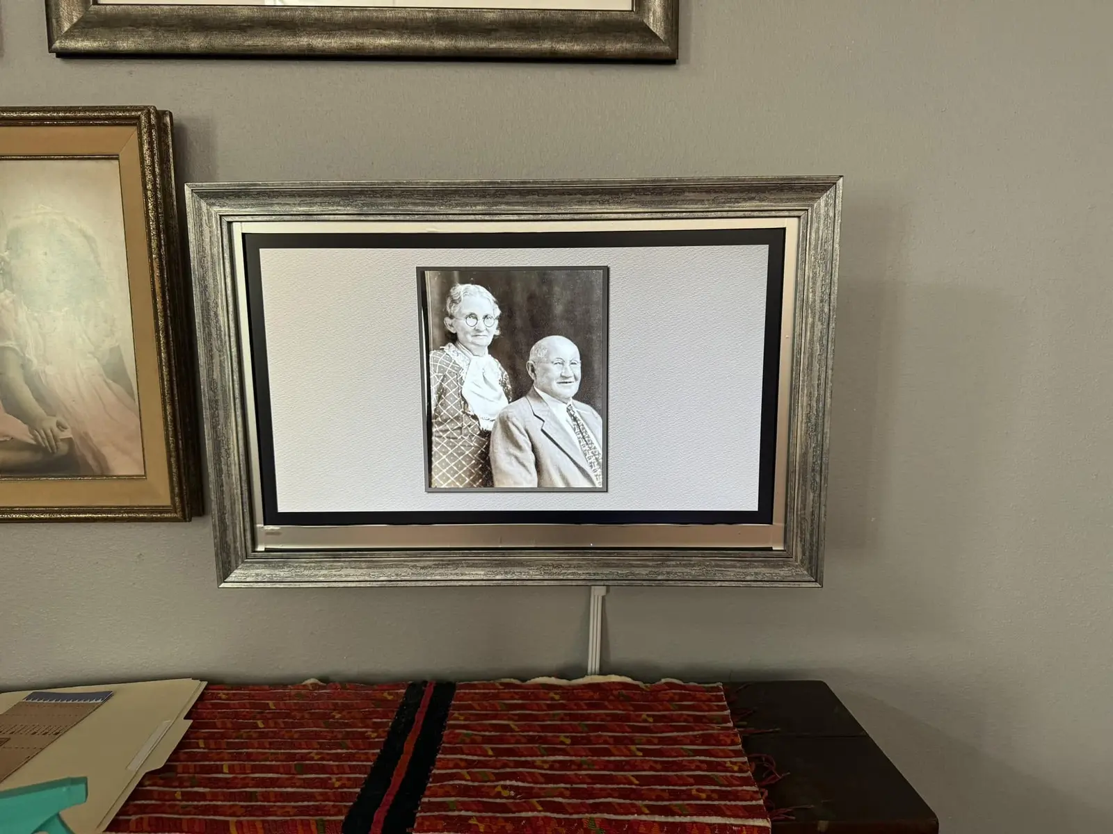 Digital picture frame mounted on wall showing a vintage family photo